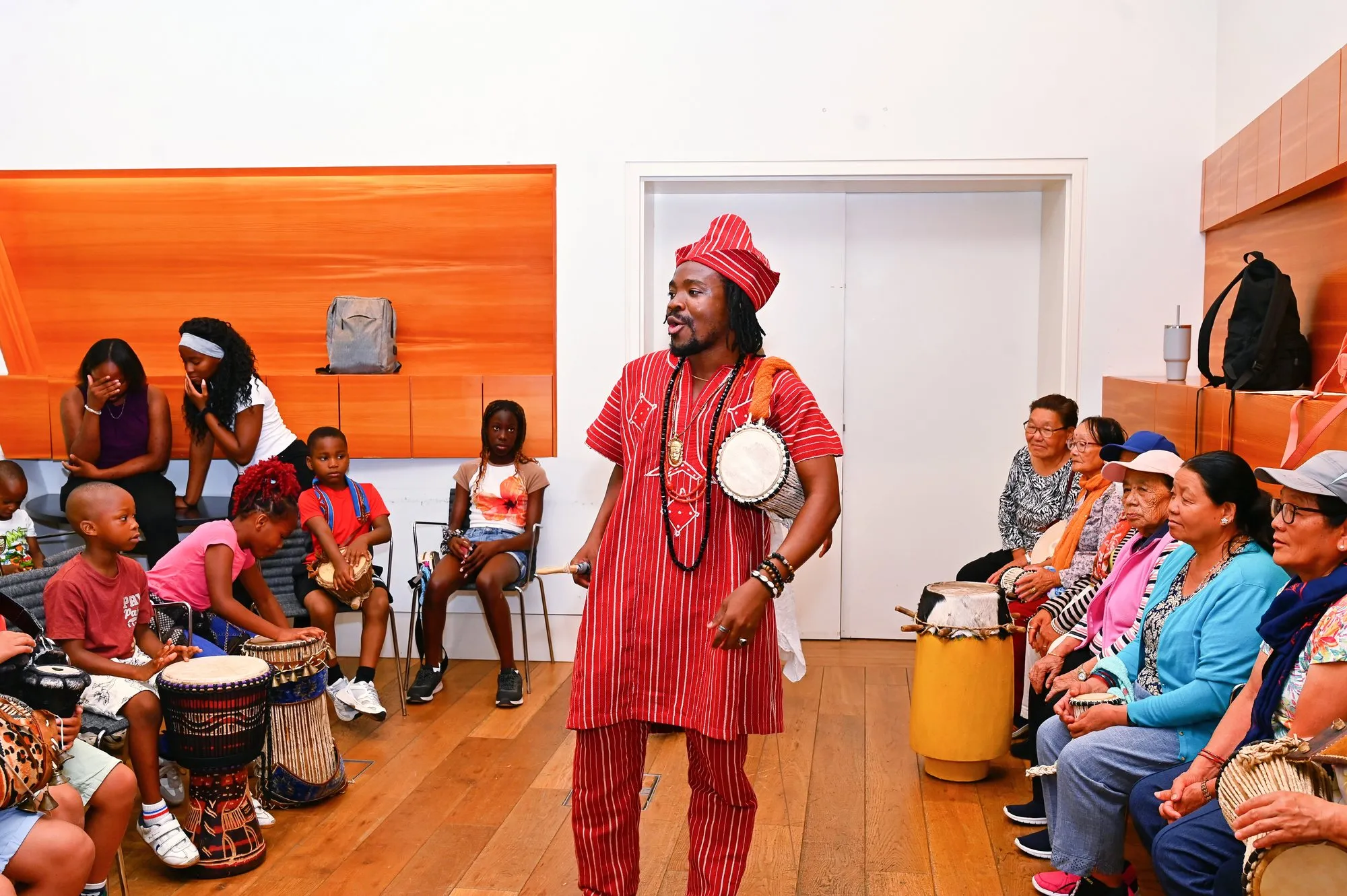 The Abuletic King leads a drum circle for children and elders