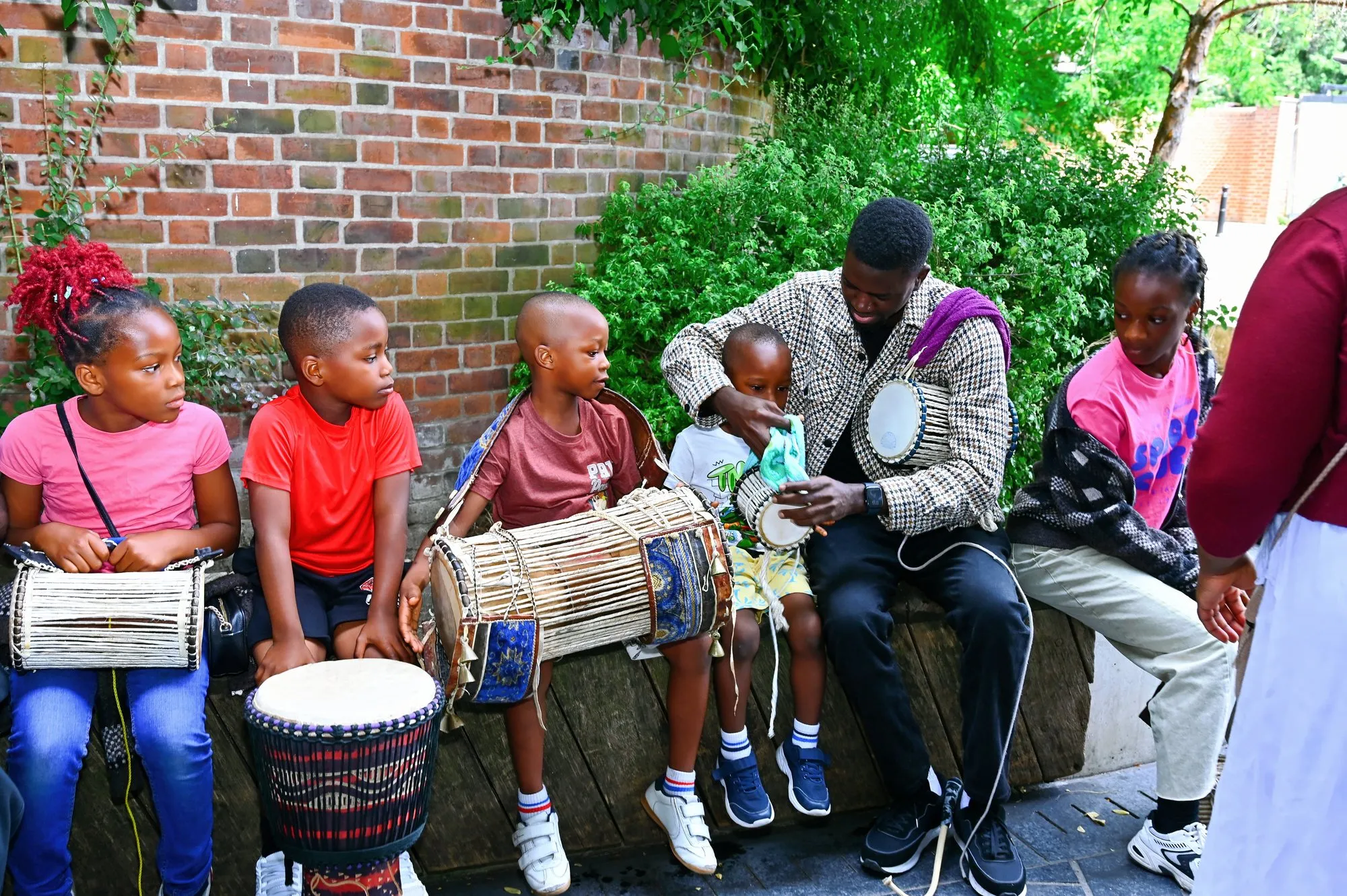 Children with the dùndún in the garden